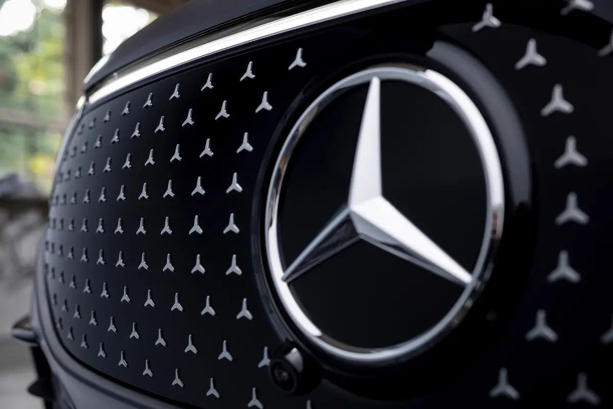 Close-up of a Mercedes-Benz logo on a sleek car grille.